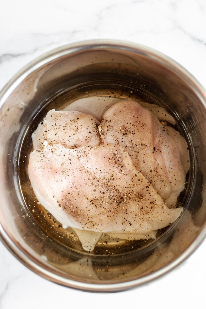 Chicken breasts layered inside of an Instant Pot.