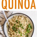 Bowl of quinoa topped with herbs. A spoon is in the bowl.