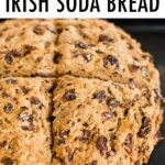 Loaf of Irish soda bread on a baking sheet. Loaf of bread is masks with a cross cut.