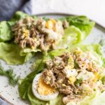 Two tuna egg salad lettuce wraps on a plate.