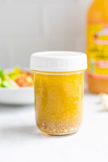 Mason jar of apple cider vinaigrette dressing.