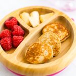 Baby plate with mini pancakes, raspberries and banana.