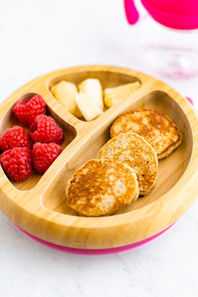 Baby plate with mini pancakes, raspberries and banana.