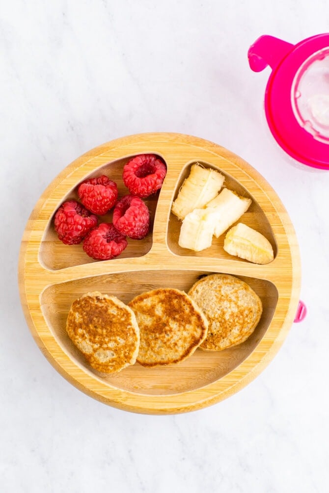 Baby plate with mini pancakes, raspberries and banana.