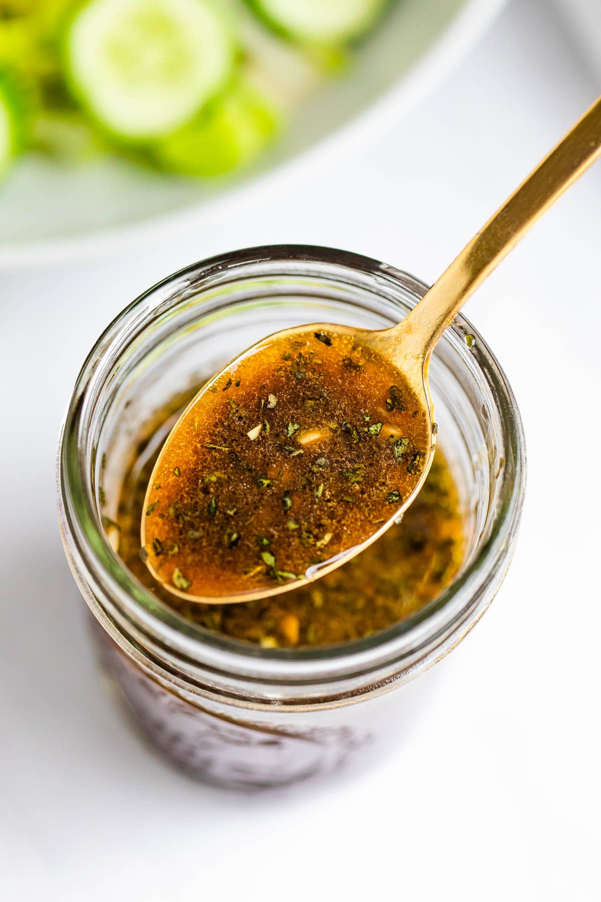 Spoon with a spoonful of balsamic dressing from a mason jar.