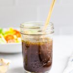 Mason jar with balsamic dressing and a spoon in the jar.