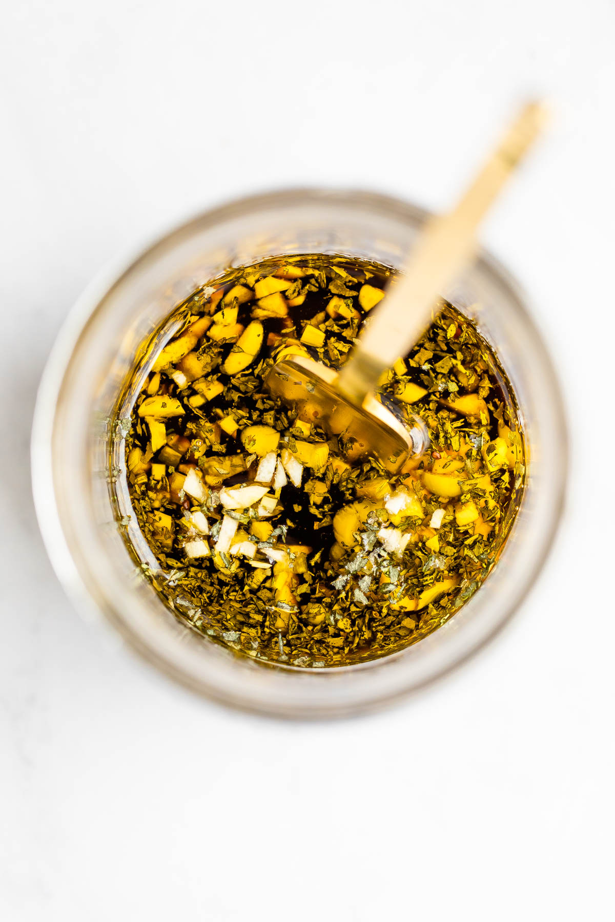 Ingredients for a balsamic dressing in a mason jar and a fork.