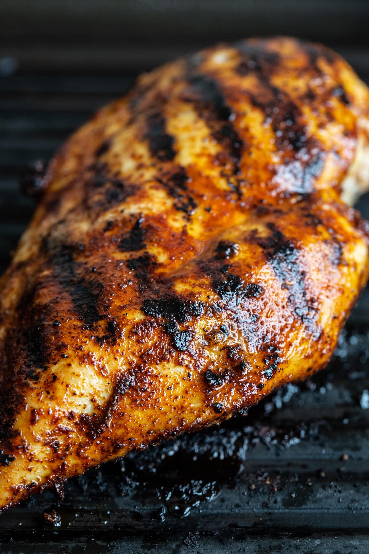 Blackened grilled chicken in a grill pan.