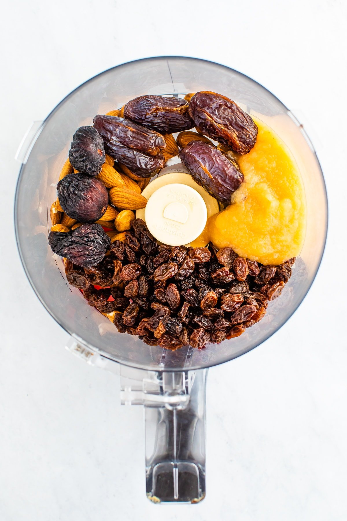 Food processor with raisin, dates, apple sauce and almonds.