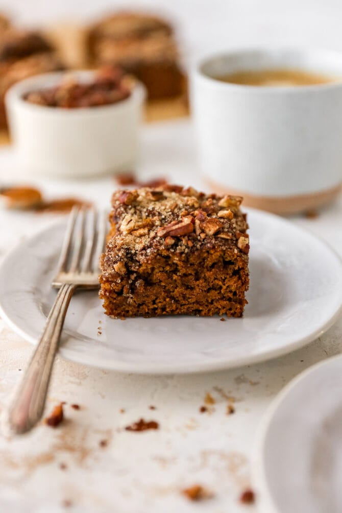 Slice of coffee cake on a plate with a fork.