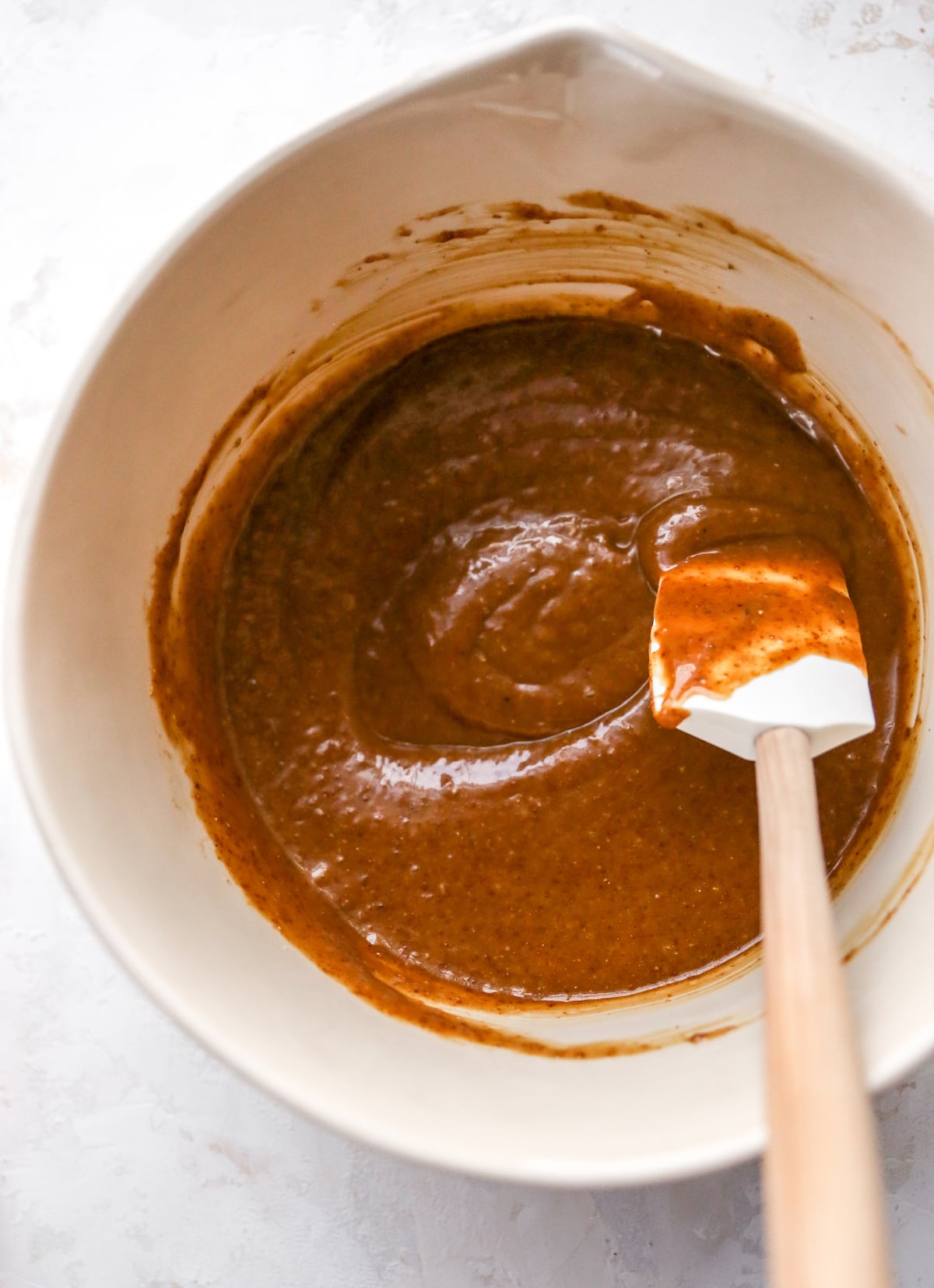 Mixing bowl of coffee cake batter with a spatula.