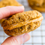 Hand holding a peanut butter sandwich cookie.