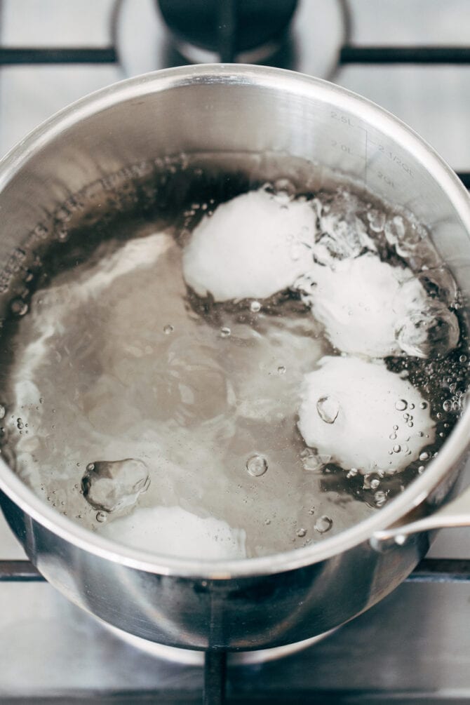 Eggs being boiled in a pot of water.