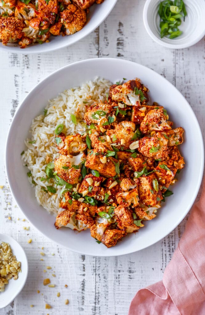 Bowl of kung pao tofu and cauliflower served with rice.