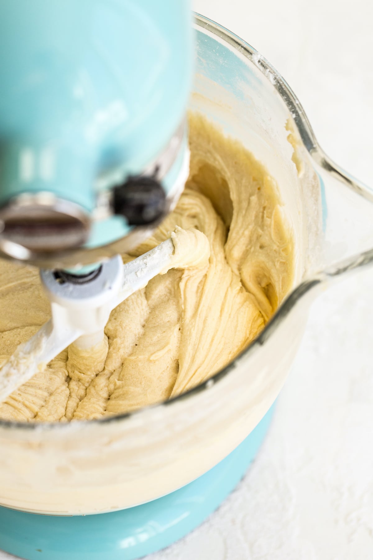 Aqua Kitchen Aid with paddle attachment mixing pound cake batter.