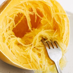 Fork pulling apart strands of spaghetti squash.