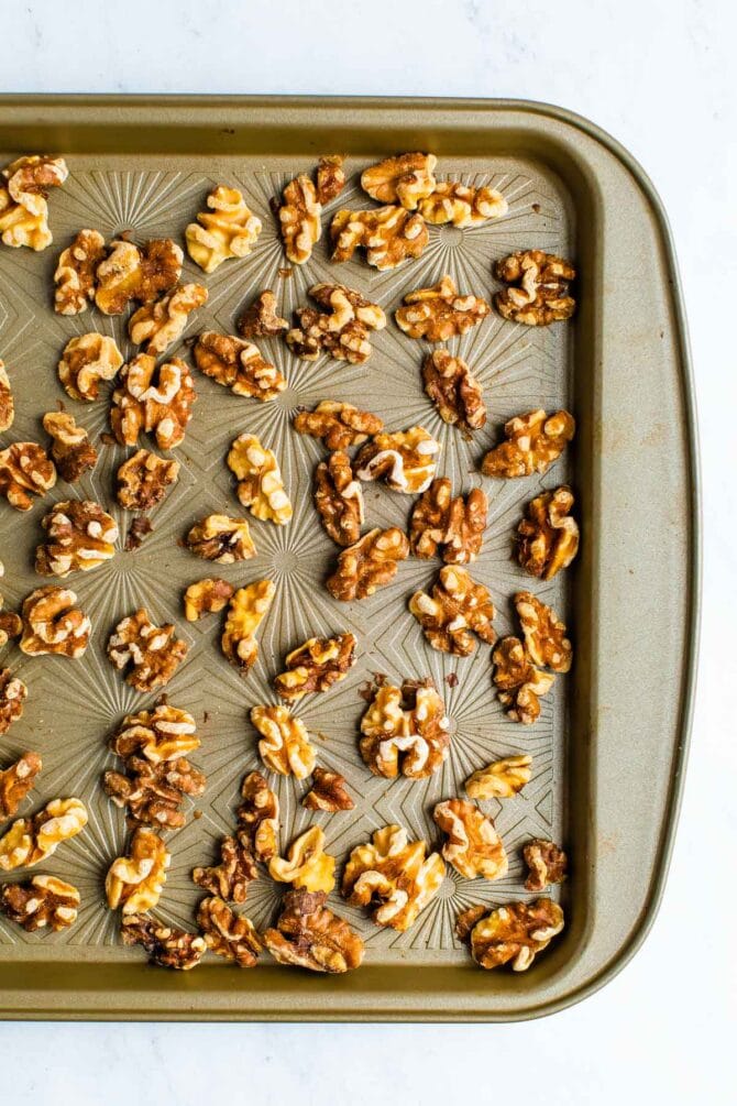 Toasted walnuts on a cookie sheet.