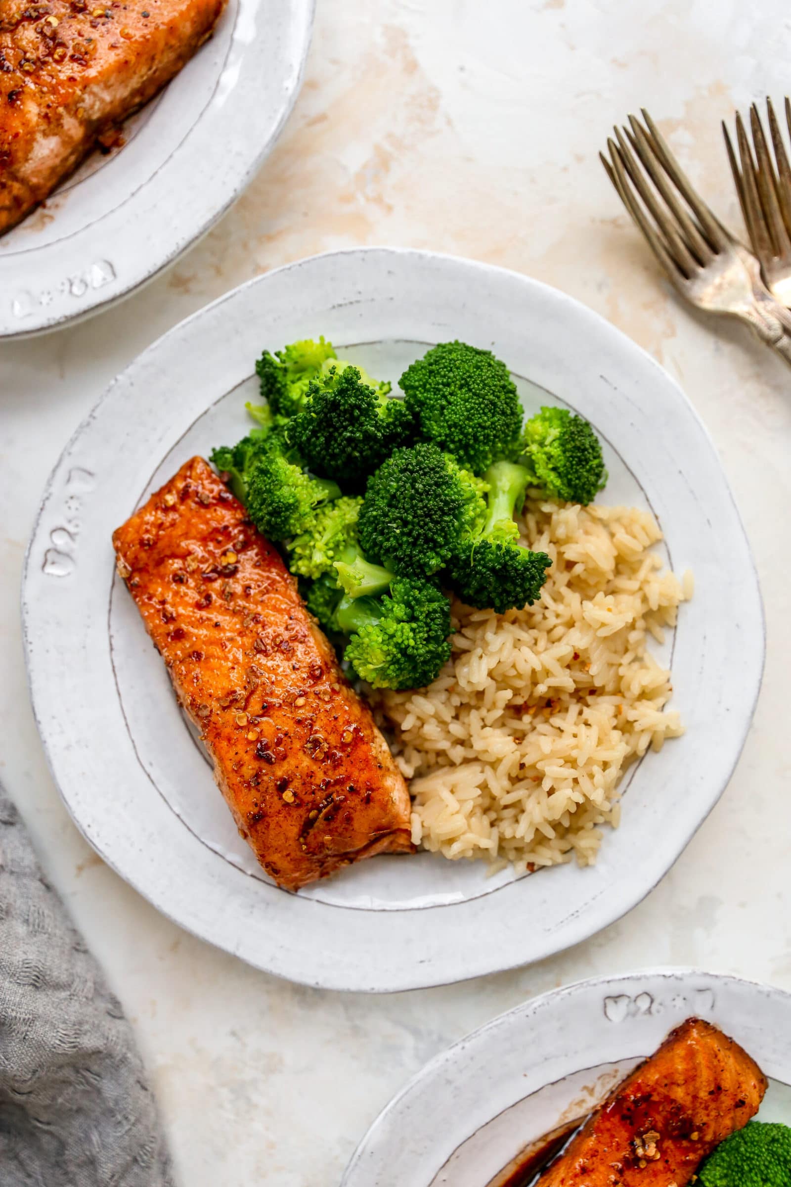 Plate with a piece of balsamic salmon, brown rice and broccoli.
