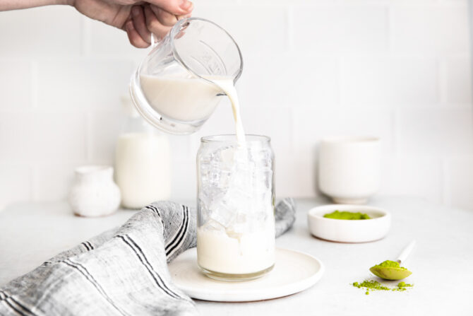 Pouring milk into a glass of ice.