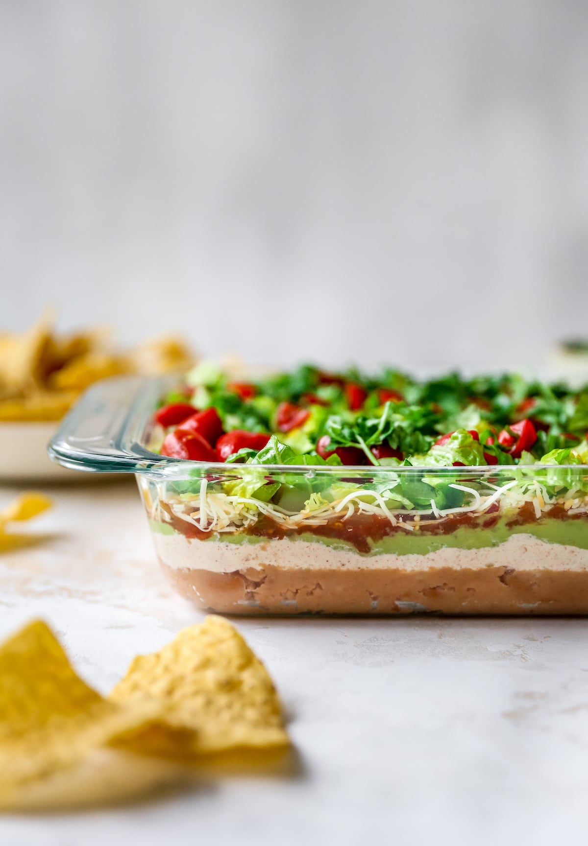 Side view of a glass dish of Mexican layer dip so you can see the layers.