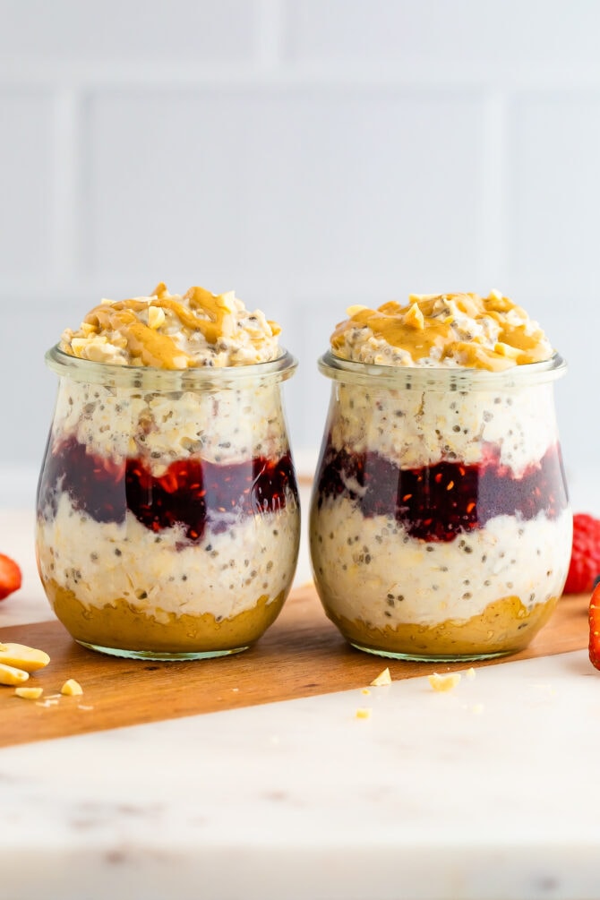 Two jars of peanut butter overnight oats layered with peanut butter and jelly.