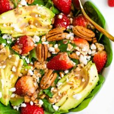 Spinach salad with avocado, strawberries, pecans, goat cheese and balsamic dressing.