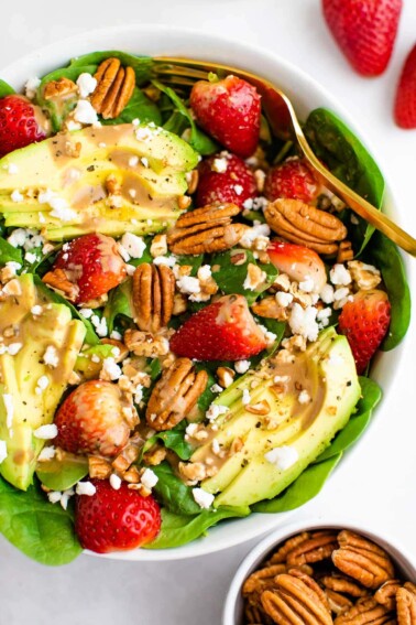 Spinach salad with avocado, strawberries, pecans, goat cheese and balsamic dressing.