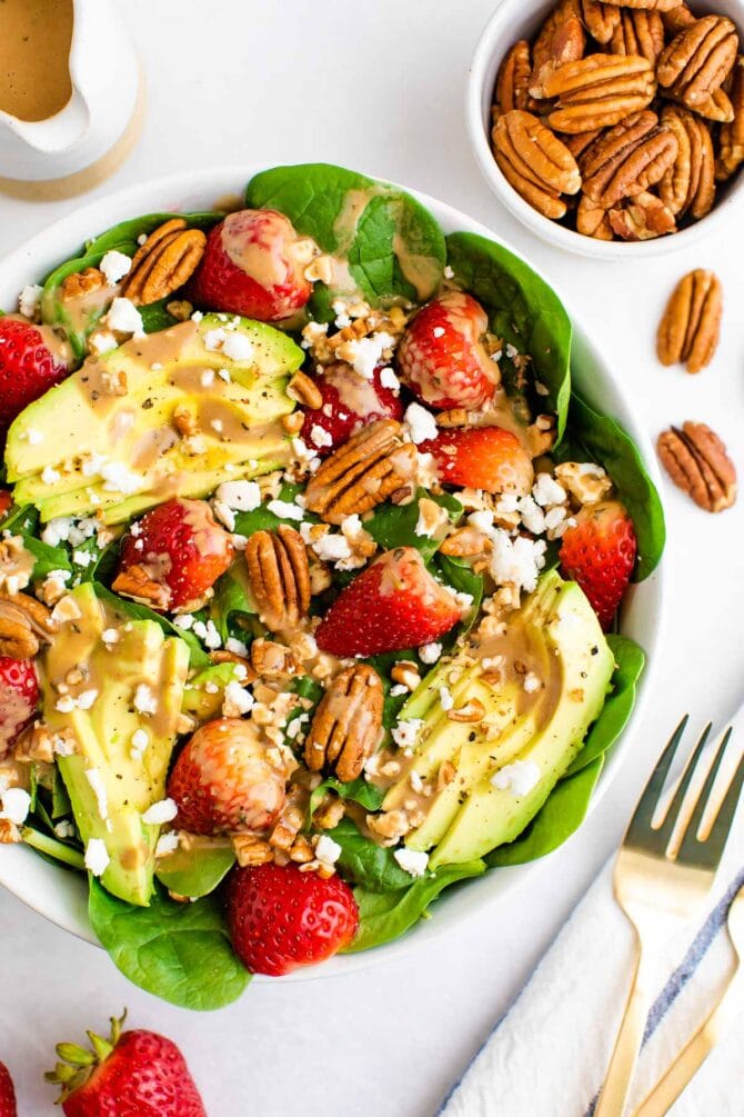 Spinach salad with avocado, strawberries, pecans, goat cheese and balsamic dressing.