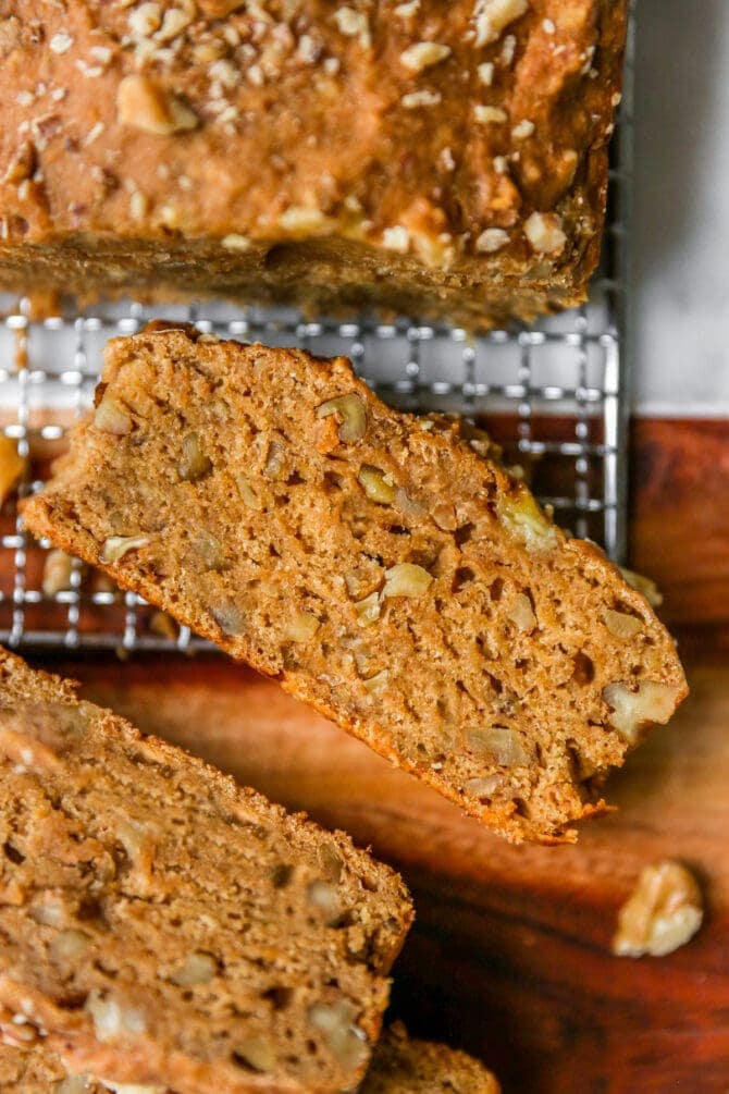 Slice of vegan banana bread on a cooling rack.