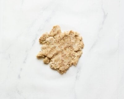 Almond flour cracker dough on a marble slab.