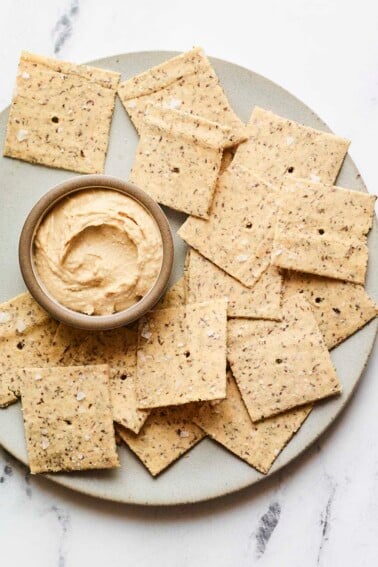 Almond flour crackers on a plate with hummus.