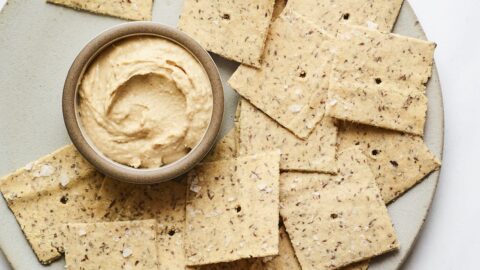 Almond flour crackers on a plate with hummus.