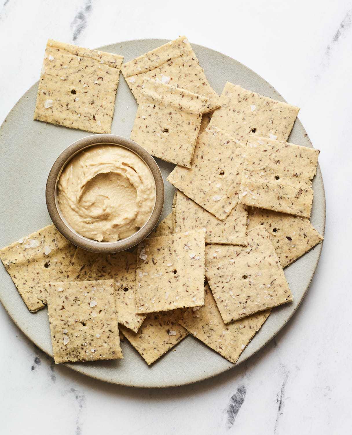 Almond flour crackers on a plate with hummus.