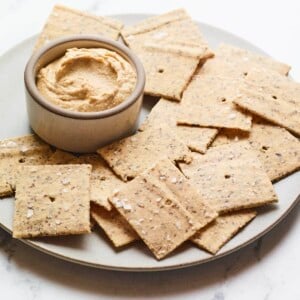 Almond flour crackers on a plate with hummus.