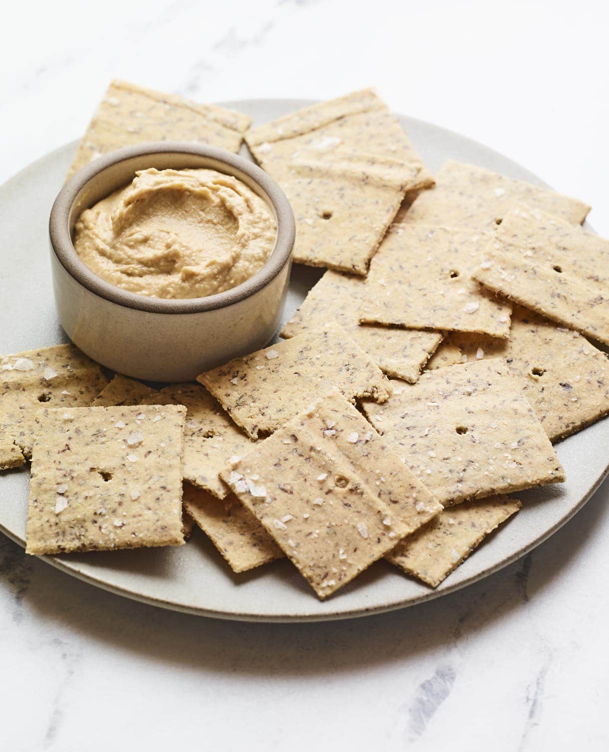 Almond flour crackers on a plate with hummus.