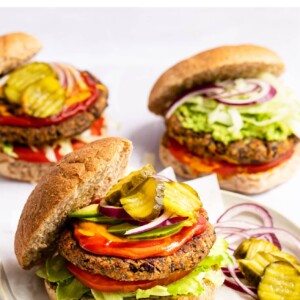 Black bean burger on a bun with lettuce, tomato, onion, ketchup, mustard and pickles.