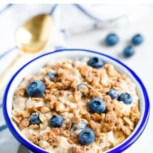 Bowl of blueberry overnight oats topped with a crumble topping and blueberries.