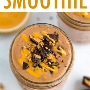 Peanut butter chocolate smoothie in a mason jar, topped with chopped peanut butter cup and peanut butter drizzle.