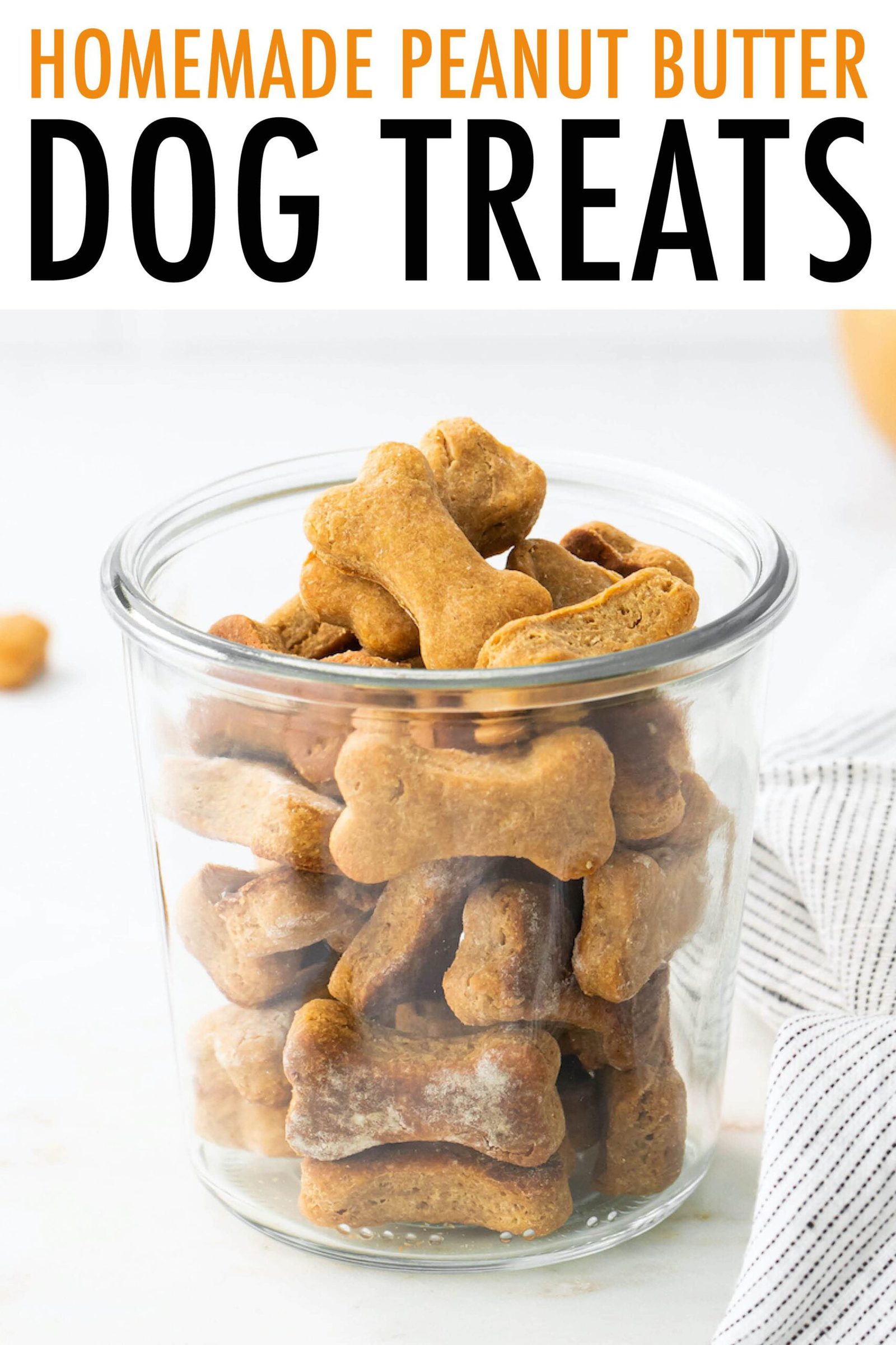 Glass jar full of peanut butter dog treats in the shape of bones.