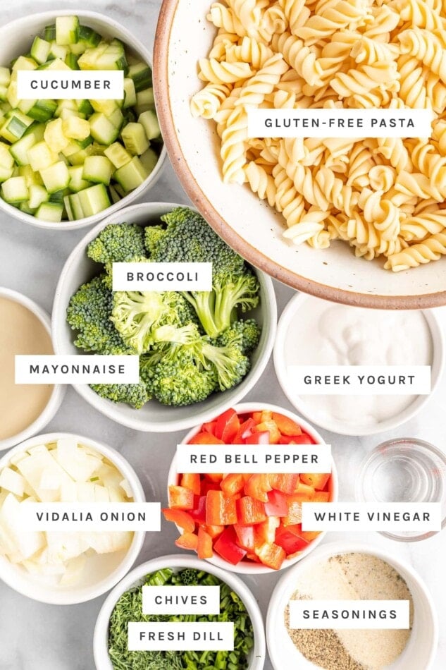 Ingredients measured out to make ranch pasta salad including pasta, veggies, Greek yogurt and herbs.