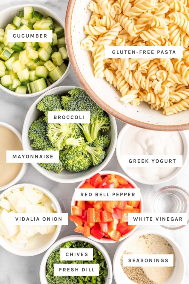 Ingredients measured out to make ranch pasta salad including pasta, veggies, Greek yogurt and herbs.