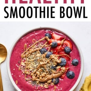 Smoothie bowl topped with berries, granola and almond butter.