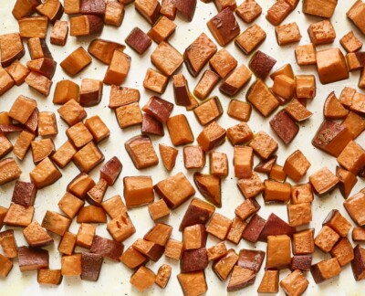 Roasted sweet potato chunks on a sheet pan.