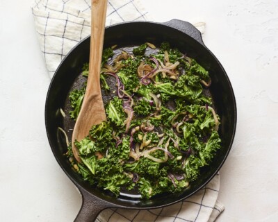 Sautéed kale and onion in a skillet.