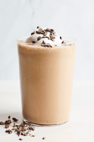Homemade frappuccino topped with whipped cream and cacao nibs.