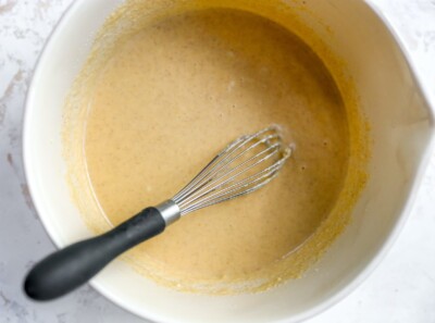 Mixing bowl and whisk with almond flour pancake batter.