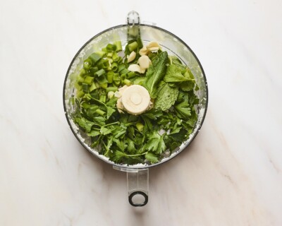 Herbs, green onion and garlic in a food processor.