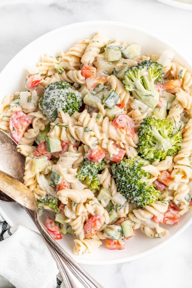 Serving bowl with ranch pasta salad with broccoli, peppers and cucumber.