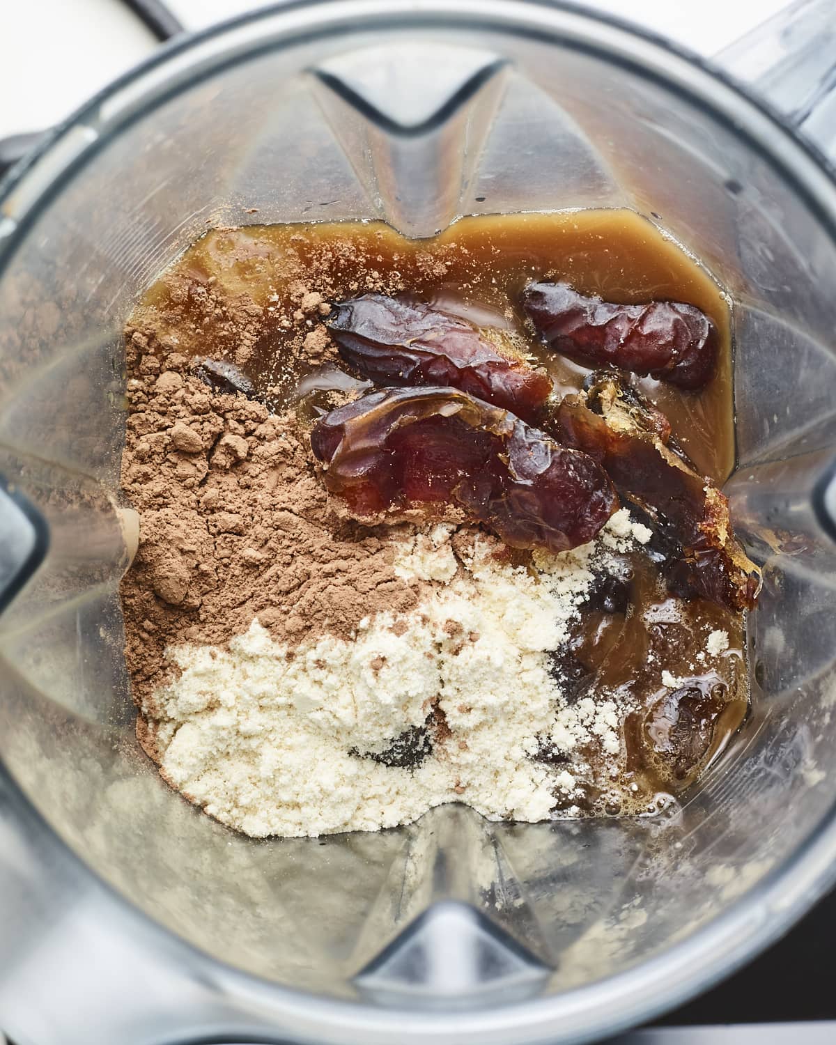 Cold brew, cocoa powder, protein powder and dates in a blender.