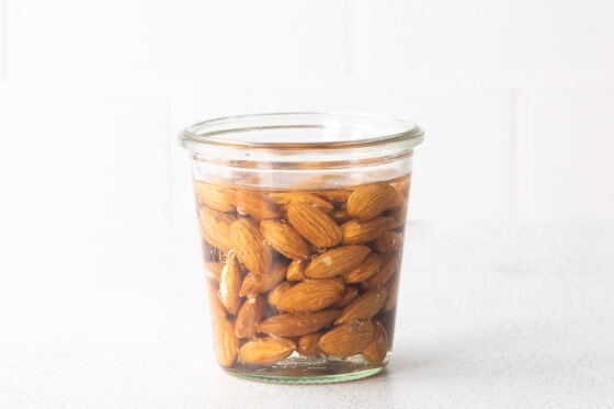 Jar of almonds soaking in water.